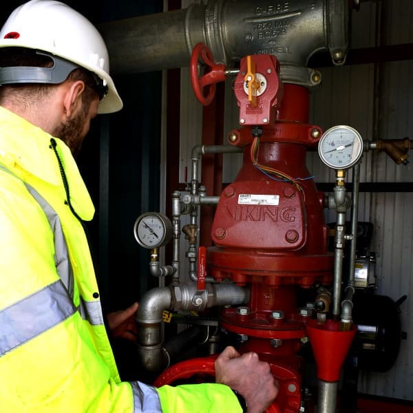 Photo of an engineer servicing a fire sprinkler system