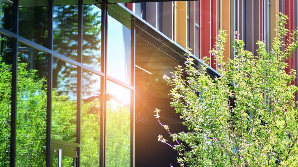image of a modern high rise building with the sun bouncing off the glass pannels