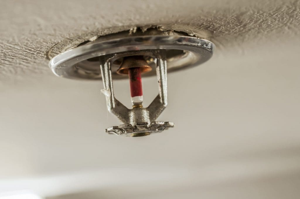 Image of a fire sprinkler in a residential building, from the celing