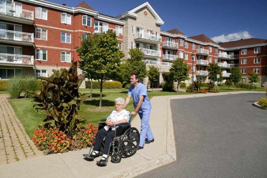Photo of a carer pushing a lady in a wheelchair