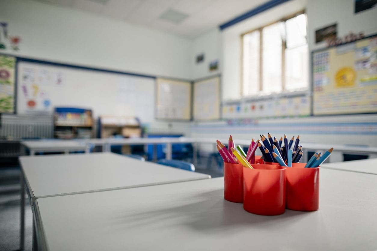 Photo of a classroom with focus on pencils in a pencil holder